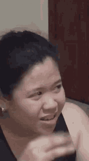 a woman is making a funny face while holding a glass .