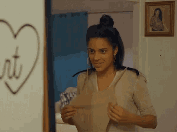 a woman is standing in front of a wall with a heart drawn on it .