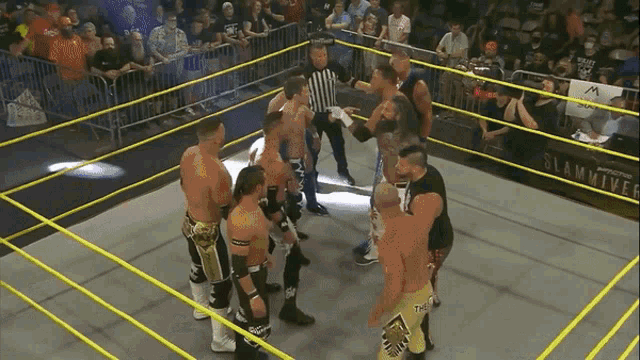 a group of wrestlers standing in a ring with a sign that says slamriver