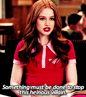 a woman in a red shirt is sitting in a chair and saying something must be done to stop this heinous villain .
