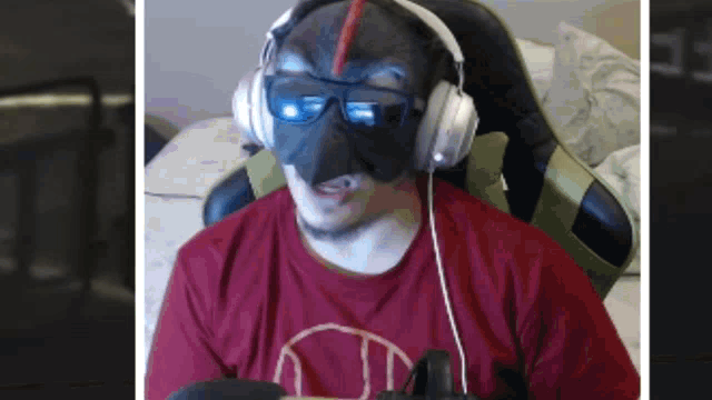 a man wearing a mask and headphones is wearing a red shirt with the letter j on it