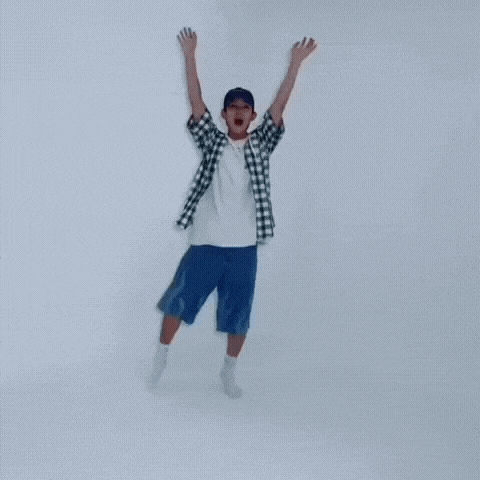 a man wearing a plaid shirt and blue shorts is jumping in the air