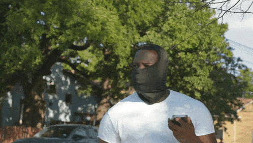 a man wearing a mask looks at his phone