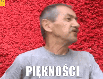 a man wearing a grey shirt with the word pięknosci written on it
