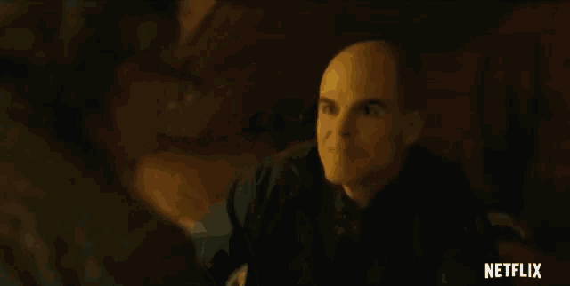 a close up of a man 's face in a dark room with a netflix logo in the corner .