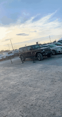 a jeep is parked in a parking lot next to other cars
