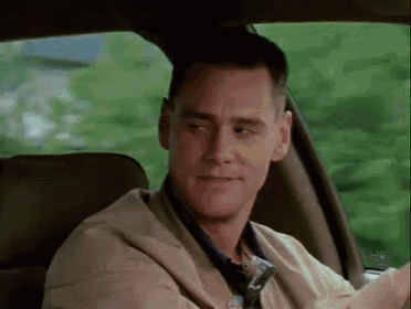 a man is sitting in the back seat of a car looking out the window .