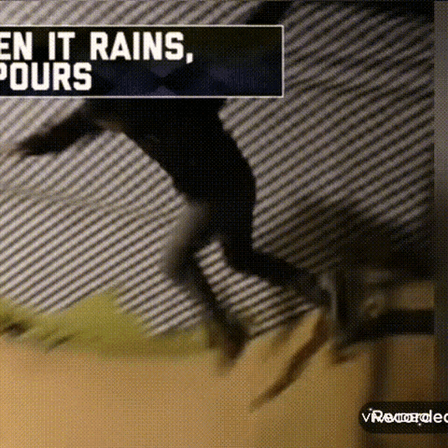 a person is jumping in the air with a sign that says en it rains , pours