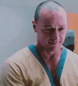 a man with a shaved head is wearing a yellow shirt and a blue collar .