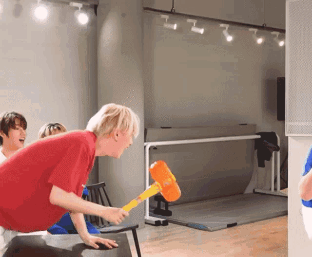 a man in a red shirt is holding a hammer