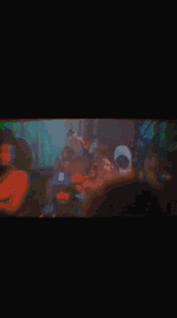 a blurry picture of a man sitting on a couch in a dark room