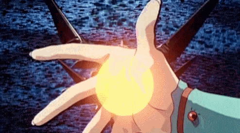 a close up of a person 's hand holding a glowing ball .