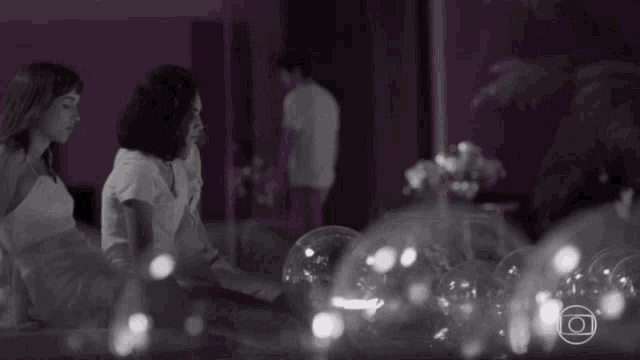 a black and white photo of a group of people standing around a table with lights .