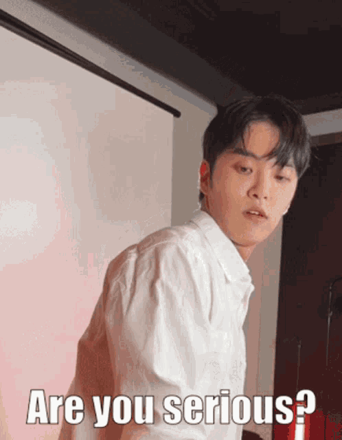 a young man in a white shirt is asking are you serious