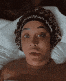 a woman laying in bed with a leopard print headband on her head