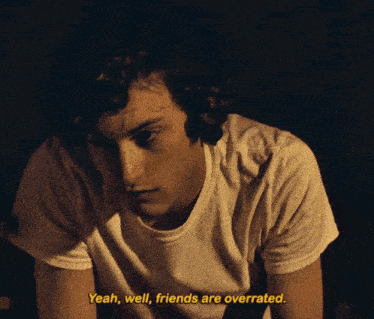 a man in a white t-shirt says yeah well friends are overrated