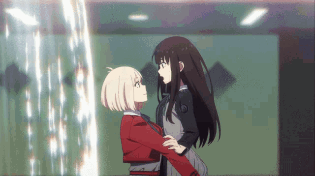 two anime girls are hugging each other and one has a circle on her chest