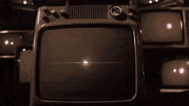a bunch of old televisions are lined up in a row