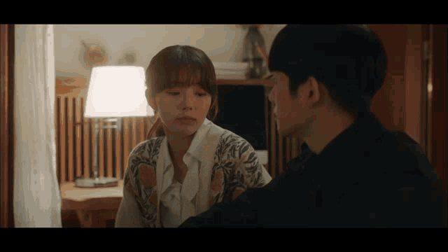 a man and woman are looking at each other in a room