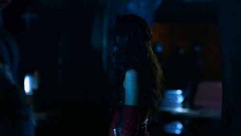 a woman in a red dress in a dark room