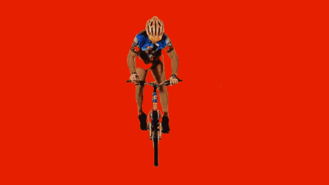 a man is drinking from a bottle while a woman rides a bicycle in the background