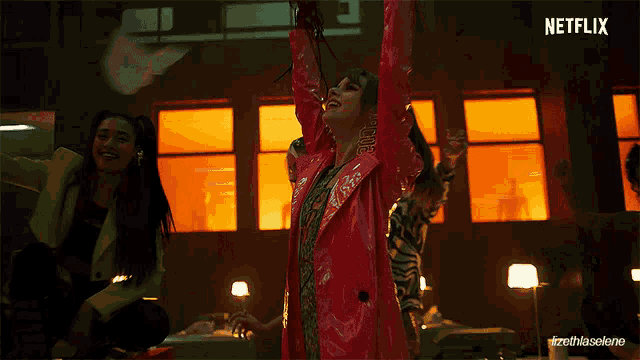 a woman in a red jacket is dancing in front of a netflix sign