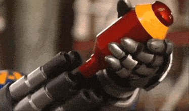 a robotic hand is holding a red object with a yellow top