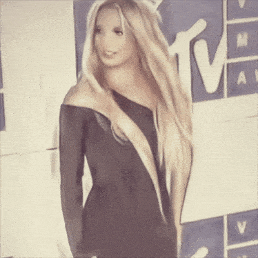 a woman stands in front of a mtv sign