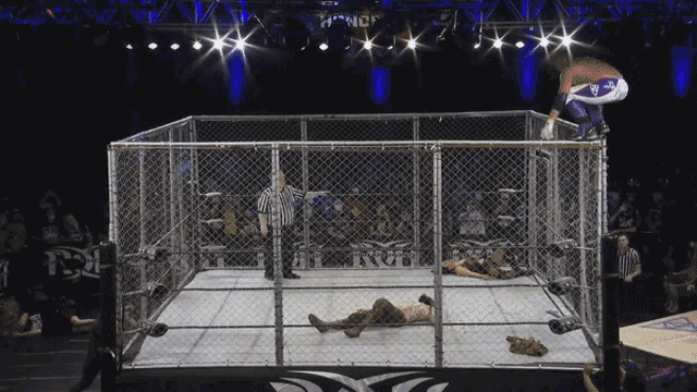 a wrestler is jumping over a chain link fence in a ring that says nct