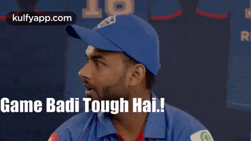 a man wearing a blue hat and a blue shirt says " game badi tough hai "