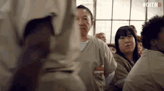a group of people are standing in a room looking at each other .