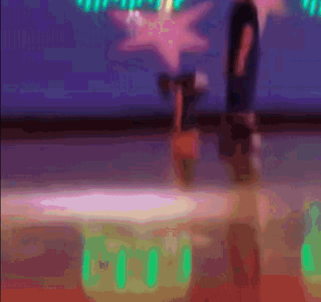 a blurred image of a person standing on a stage with a pink star in the back