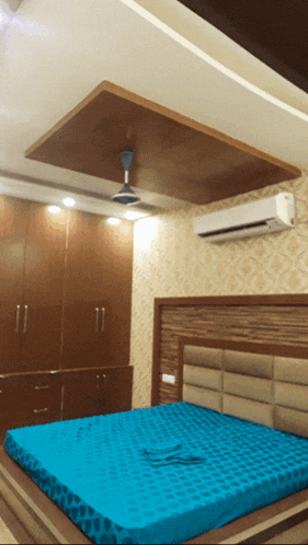 a bedroom with a ceiling fan and a blue mattress