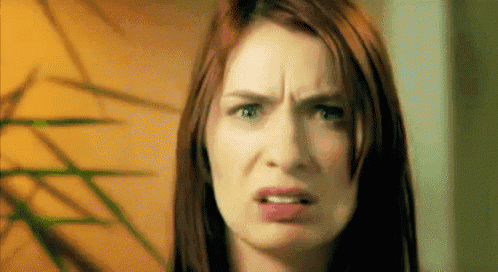 a close up of a woman making a funny face with her mouth open .