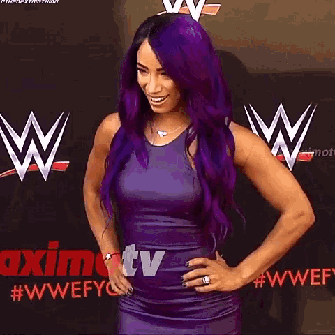 a woman with purple hair is standing in front of a sign that says w.