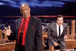 a man in a suit and tie is standing in front of another man in a suit