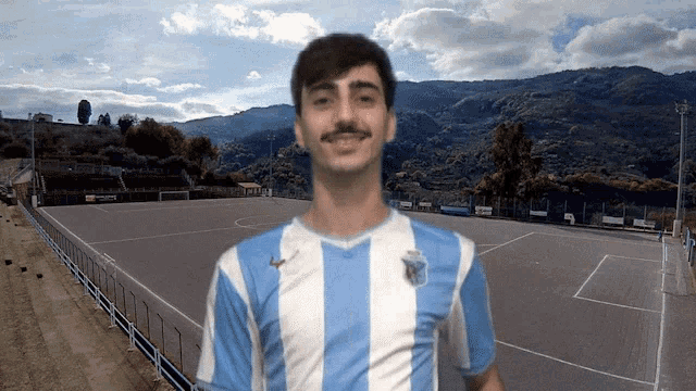 a man wearing a blue and white striped shirt is smiling