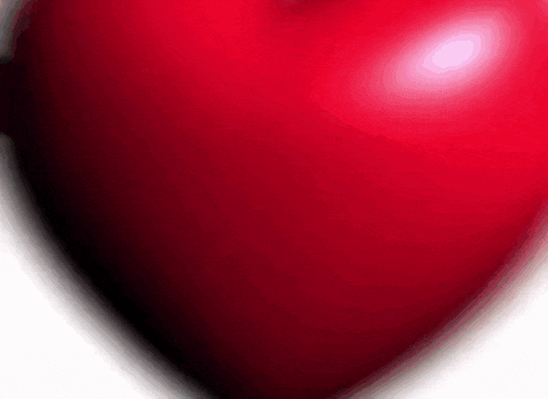 a close up of a red heart with a shadow on a white background .