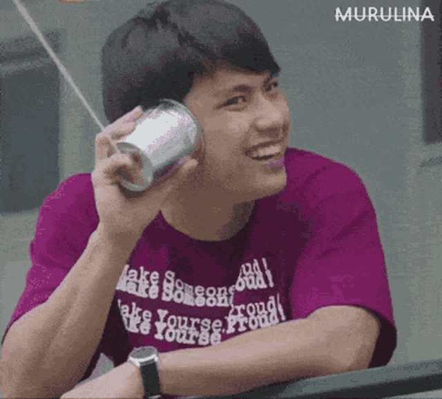 a young man wearing a purple shirt that says " make someone good "
