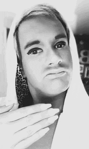 a black and white photo of a man wearing a hood