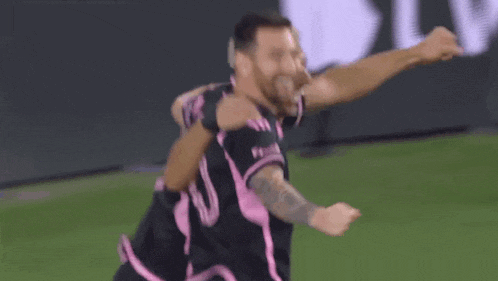 two soccer players are hugging each other on a field