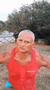 a man in a red tank top that says twg fly on it