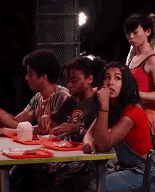 a group of people are sitting at a table with plates of food on it .