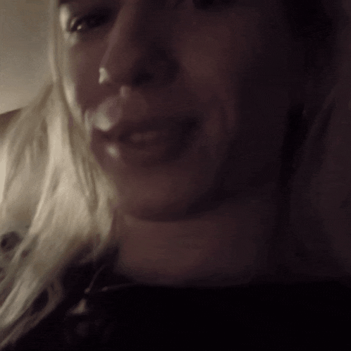 a close up of a woman 's face with a black shirt on