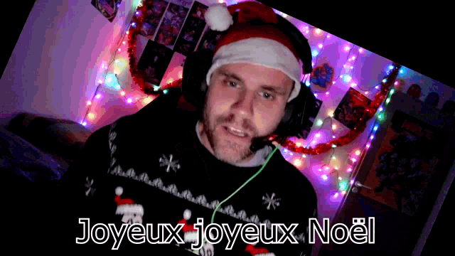 a man wearing headphones and a santa hat says joyeux joyeux noël