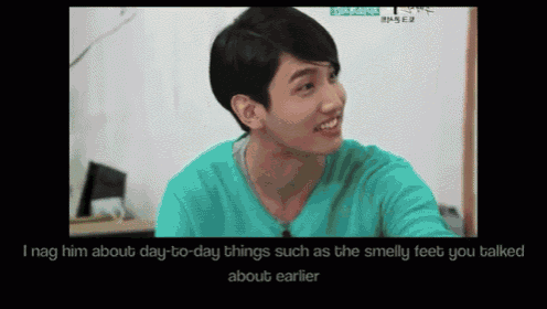 a man in a green shirt is smiling and talking to someone