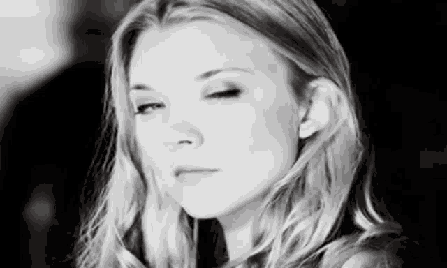 a close up of a woman 's face in a black and white photo .