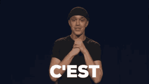 a man with his arms outstretched is wearing a black shirt with the word une on it