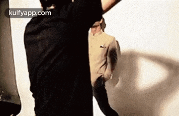 a man in a black shirt is standing next to a woman in a white shirt and holding a bag .