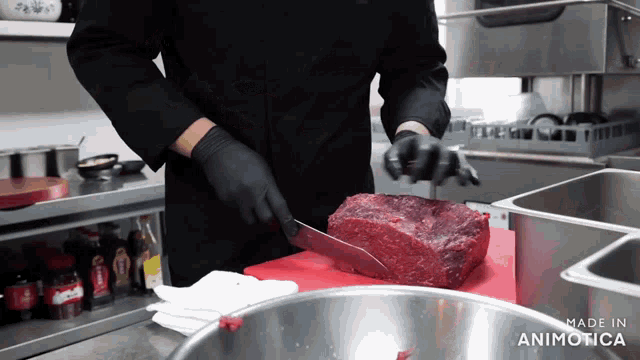 a chef is cutting a large piece of meat on a red cutting board with the words made in animatica visible in the corner